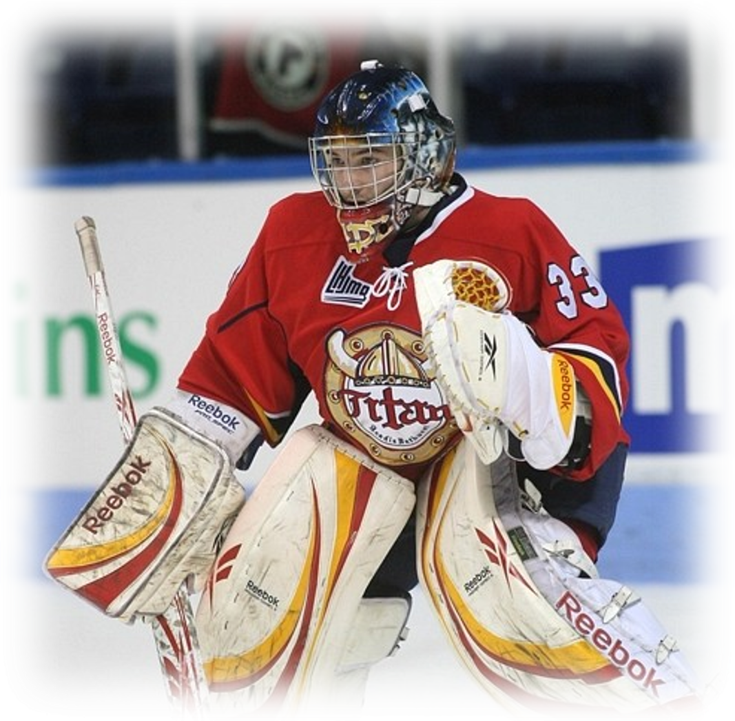 Gardien de but de hockey équipé de jambières, bloqueur et mitaine, concentré pendant un match