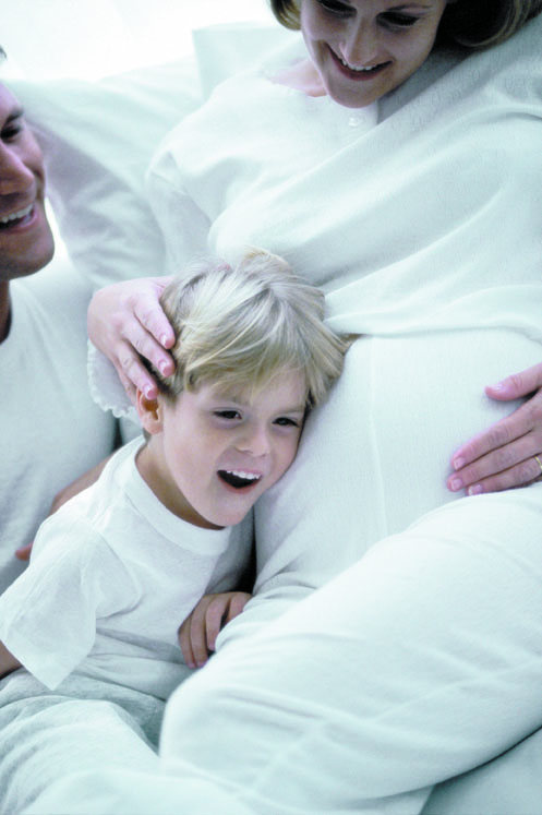 Famille attendant un bébé illustrant les bienfaits des soins chiropratiques pendant la grossesse.